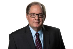 Headshot of Bruce Dold (BSJ77, MSJ78) wearing a suit and tie.