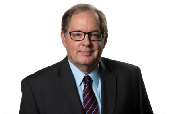 Headshot of Bruce Dold (BSJ77, MSJ78) wearing a suit and tie.